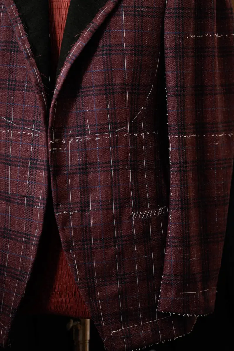 Close view of the jacket front and pocket area, crossed by chalk lines and white threads