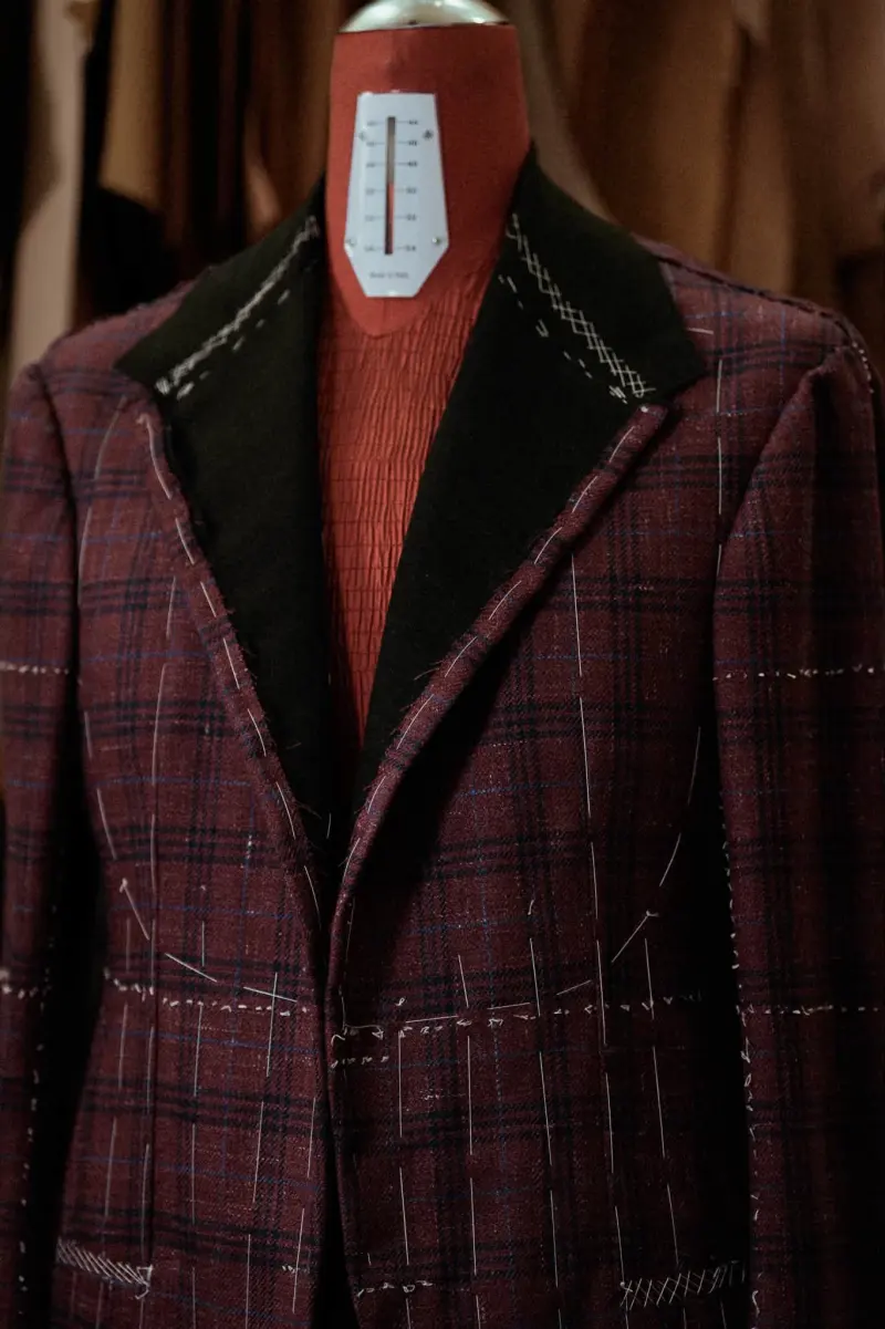 Close view of the unfinished jacket front, with white threads along the edge of the lapel