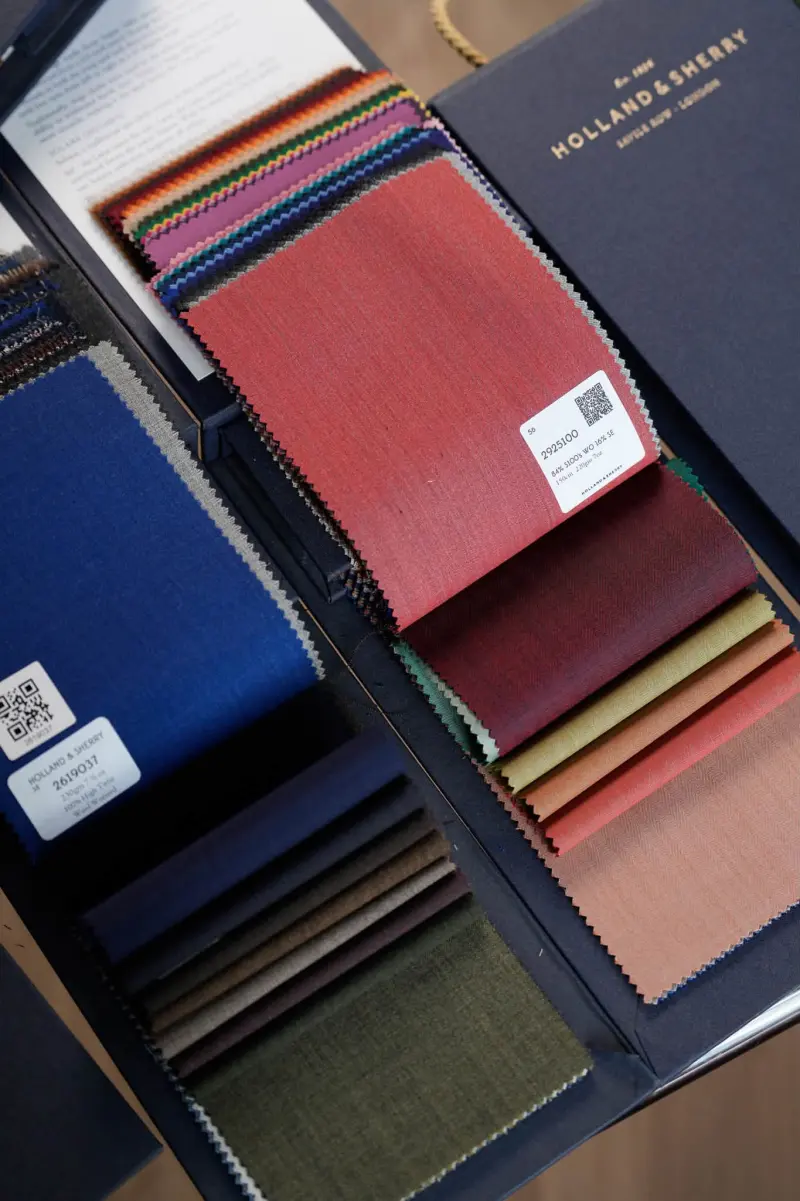 An open cloth book showing swatches in red, blue, green and neutral tones