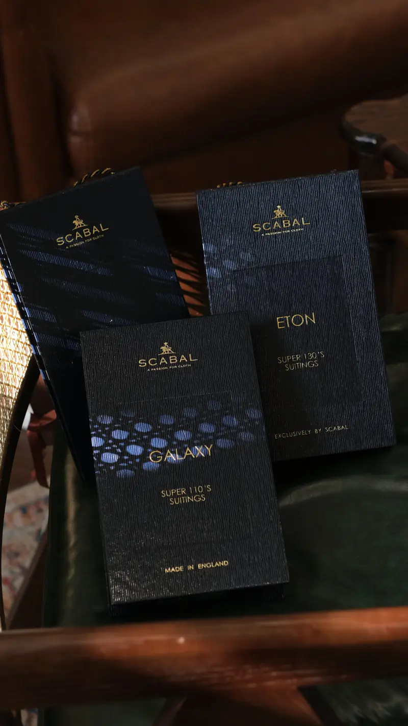 Scabal cloth bunch books on a wooden table