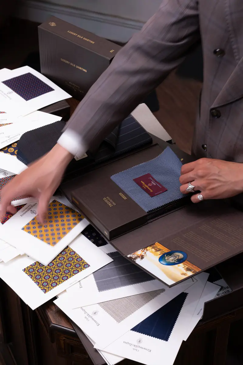 Cloth swatches and bunch books spread across a table